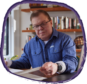 Jason, living with Hunter syndrome, reading at a desk