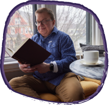 Jason, adult living with hunter syndrome, reading a book