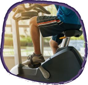 Man in shorts cycling on a gym bike