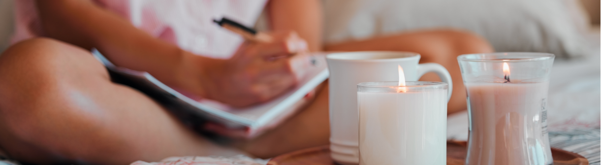 Person relaxing with candals and a notebook