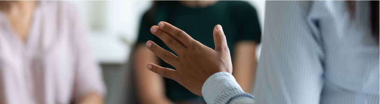 Person in a blue shirt speaking with two other people